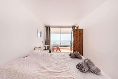 a white bedroom with a bed with towels on it at Casa Bela Vista in Sesimbra
