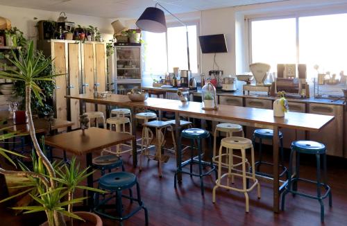 une cuisine avec un bar avec des tabourets et des tables dans l'établissement Les Abeilles, à Saint-Nazaire