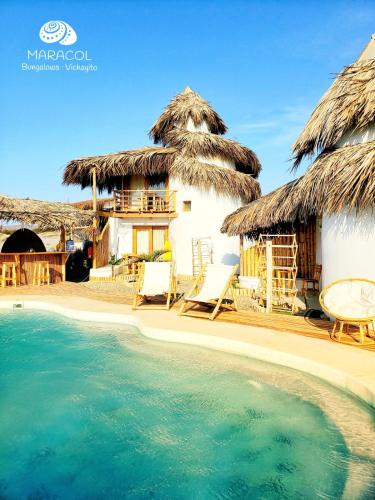 a resort with a swimming pool and a house at Maracol Bungalows Vichayito in Vichayito