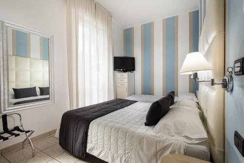 a bedroom with a bed with blue and white stripes at Hotel Flora in Milano Marittima