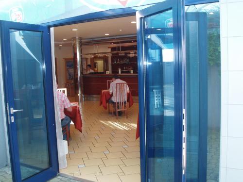 an open glass door of a restaurant with a table at Ramada Airport Hotel Prague in Prague