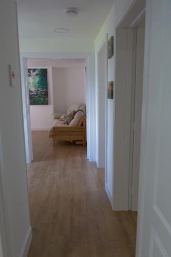 a hallway with a couch in a white room at Kirkside Holiday Home in Alness