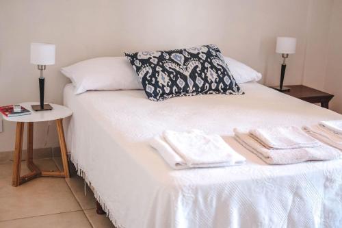 a bed with white sheets and towels on it at Departamento amplio, nuevo y céntrico in Posadas