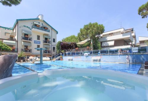 a swimming pool with a hotel in the background at Hotel Flora in Milano Marittima