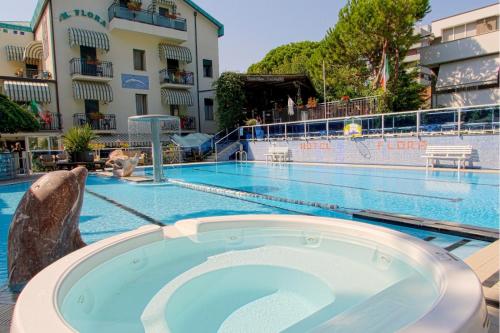 a pool at a hotel with a dolphin in the middle at Hotel Flora in Milano Marittima