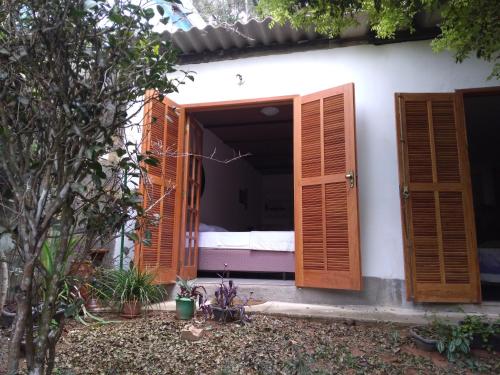 a bedroom with wooden doors and a bed in it at Loft da Montanha (A 8min do centro) in Nova Friburgo