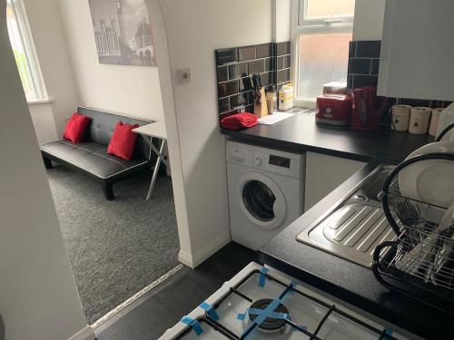 a kitchen with a washing machine in a kitchen at Watford Town centre Apartment in Watford