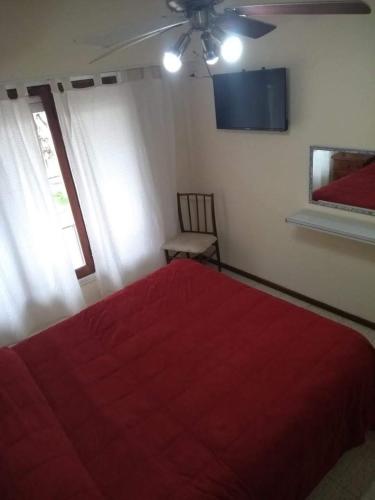 a bedroom with a red bed and a chair at Hotel Neptuno in Miramar