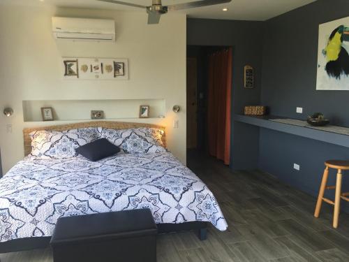 a bedroom with a bed with a blue and white comforter at La Colina Pura Vista in Bejuco