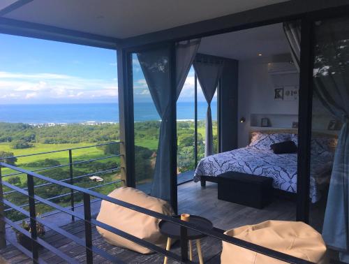 a bedroom with a bed and a view of the ocean at La Colina Pura Vista in Bejuco