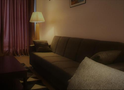 a living room with a couch and a lamp at Grand Hotel Central Conakry in Conakry