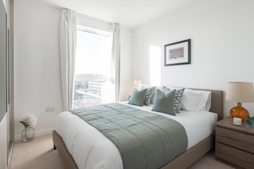 Schlafzimmer mit einem großen Bett und einem Fenster in der Unterkunft LUXURY 2Bed & 2Bath Apartment Next to London Museum in The Hyde