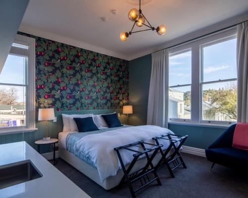 a bedroom with a bed with a floral wallpaper at The Vicarage Geraldine in Geraldine