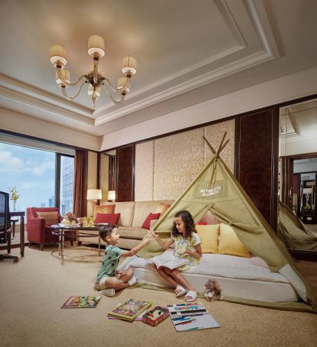 a woman and a child sitting on a bed with a tent at Shangri-La Kuala Lumpur in Kuala Lumpur