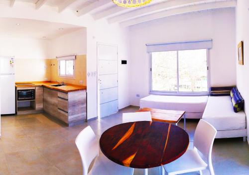 cocina y sala de estar con mesa y sofá en Departamentos La Esquina en Villa Gesell