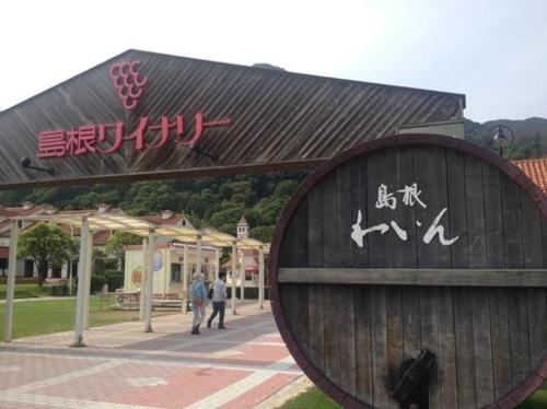 a sign in front of a building with writing on it at COCORETO The Guesthouse Daikon Island in Matsue