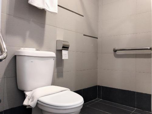 a bathroom with a white toilet and a towel rack at Tumike Hotel Bentong in Bentong