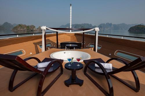 a table and chairs on the deck of a boat at Scarlet Pearl Cruises - Wonder On Lan Ha Bay in Ha Long