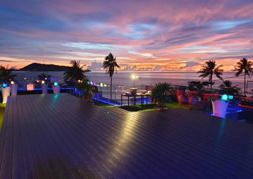 a view of the ocean from a deck at sunset at The Nature Phuket - SHA Extra Plus in Patong Beach