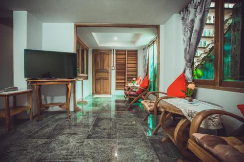a living room with a television and a couch at Sasitara Thai Villas in Choeng Mon Beach