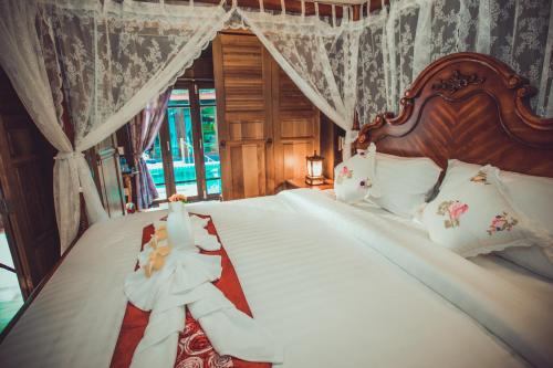 a bedroom with a bed with white sheets and pillows at Sasitara Thai Villas in Choeng Mon Beach