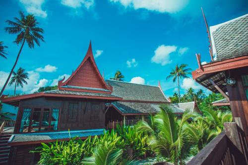a house on a tropical island with palm trees at Sasitara Thai Villas in Choeng Mon Beach