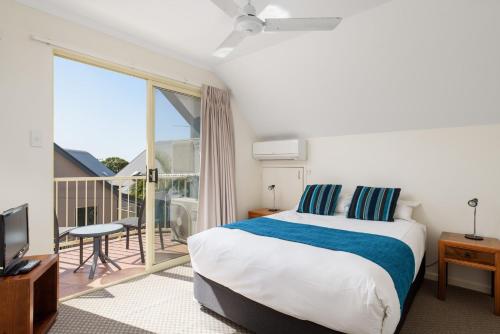 a hotel room with a bed and a balcony at Rainbow Getaway Holiday Apartments in Rainbow Beach