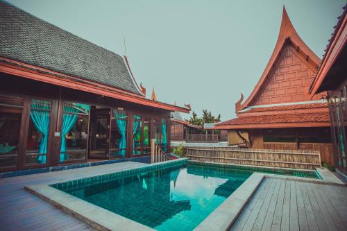 a swimming pool in front of a building at Sasitara Thai Villas in Choeng Mon Beach