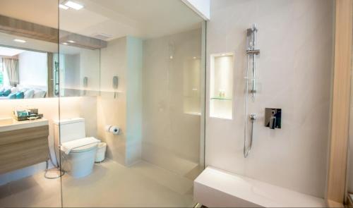 a bathroom with a toilet and a glass shower at Phuket Graceland Resort and Spa - SHA Extra Plus in Patong Beach