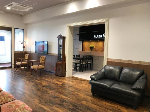 a living room with a couch and a table at ビジネスインホテルプラザ21大阪京橋 in Osaka