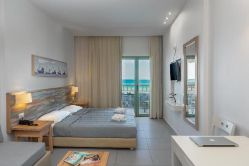 a bedroom with a bed and a view of the ocean at Erato Beach Hotel Adults Only by Smile Hotels in Platanias