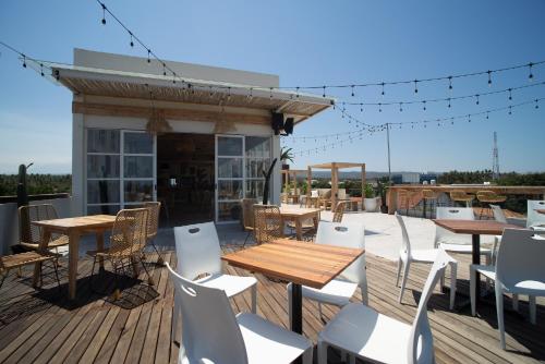 a deck with tables and chairs on a roof at Luminor Hotel Banyuwangi By WH in Banyuwangi