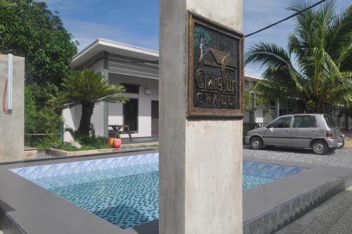 a sign on the side of a building with a swimming pool at Changlun Chalet in Changlun