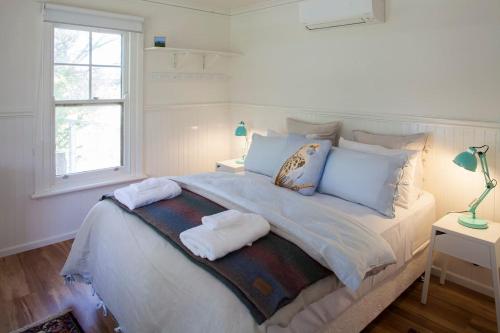 a bedroom with a large bed with towels on it at Bird House in Kyneton