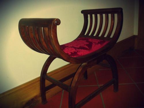 a wooden chair with a red seat in a room at Quinta Da Penela in Vieira do Minho