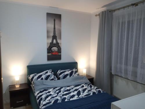 ein Schlafzimmer mit einem Bett und einem Eiffelturm in der Unterkunft Apartament Słoneczny in Augustów