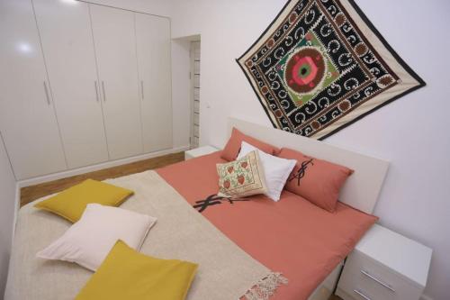 Un dormitorio con una cama con almohadas de colores. en Newly Renovated Modern 2 Bed Apt Near Gur-e-Amir, en Samarkand