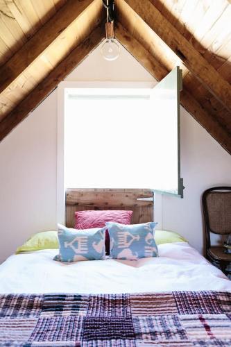 a bed with two pillows and a window in a room at Harpsichord House in Kyneton