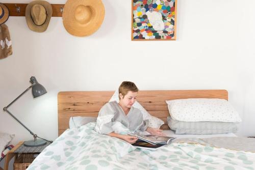 a young girl sitting in bed reading a book at Harpsichord House in Kyneton