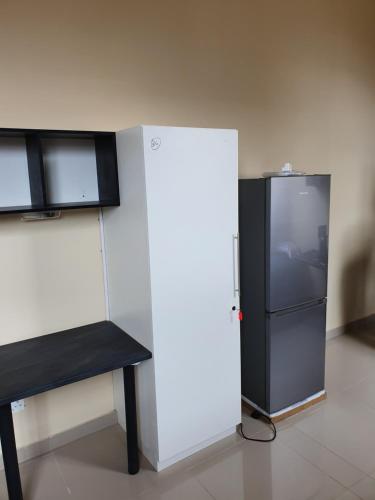 a refrigerator and a bench in a room at Oasis Residence in Durban