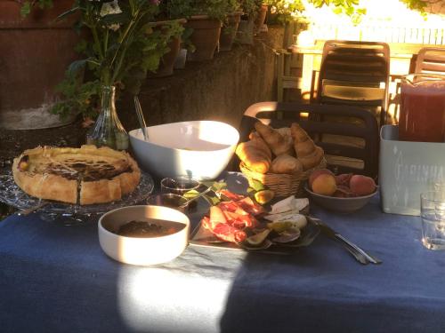 La Belle Etoile Chambres في Roaix: طاولة عليها مفرش أزرق عليها خبز وأطعمة أخرى