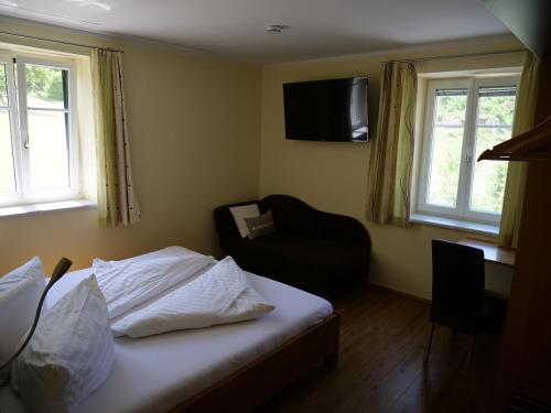 a bedroom with a bed and a chair and a television at Lugerfarm in Melk