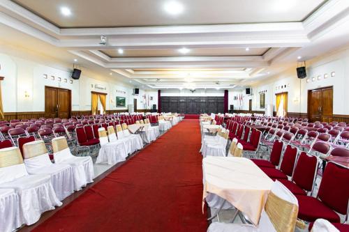 a banquet hall with red and white tables and chairs at RedDoorz Plus near Alun Alun Karanganyar in Karanganyar