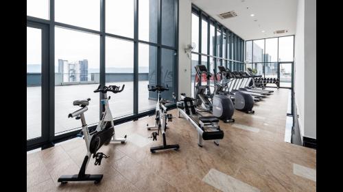 a gym with a row of treadmills and exercise bikes at 3 Towers 10min to KLCC next to Hospital Gleneagle in Kuala Lumpur