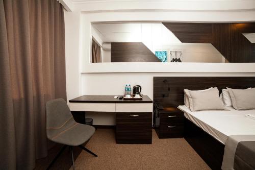 a bedroom with a bed and a desk and a bed at Meridian in Karagandy