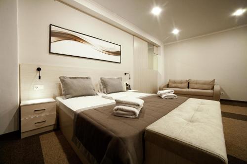 a bedroom with two beds and a couch at Meridian in Karagandy