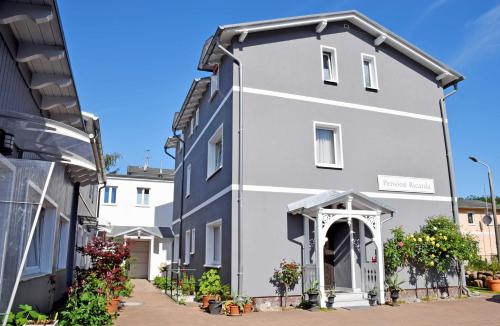 una casa blanca con un arco en una calle en Pension im Ostseebad Sellin, en Ostseebad Sellin