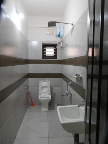 a bathroom with a toilet and a sink at Coral Homes in Cochin