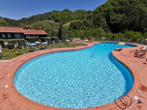 une grande piscine dans un complexe avec des montagnes en arrière-plan dans l'établissement Hotel Marrani, à Ronta