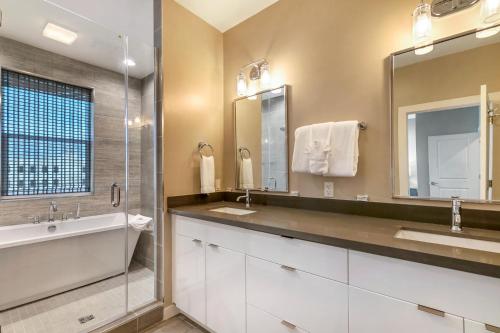a bathroom with two sinks and a large mirror at New Construction Elegant Villas in New Orleans